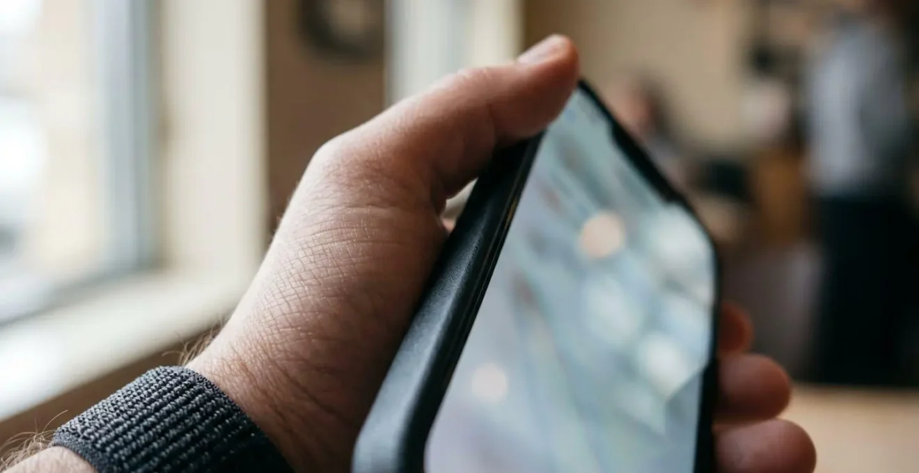 Mains d'un joueur de tennis analysant des données de performance sur un smartphone