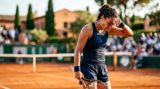 Joueur de tennis professionnel s'hydratant sur un court extérieur lors d'une journée ensoleillée en France