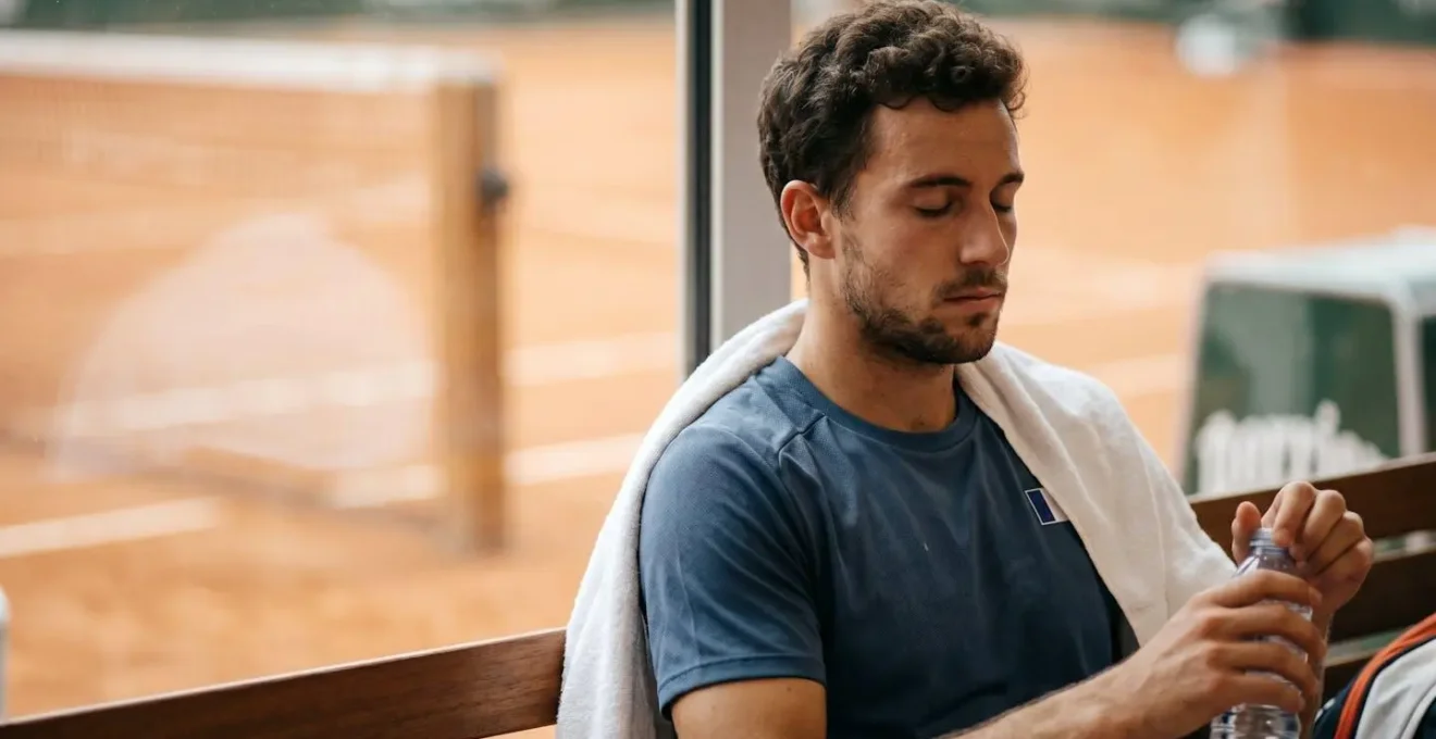 Joueur de tennis en moment de réflexion tactique au changement de côté