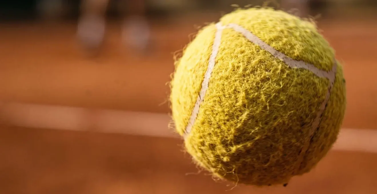 Vue macro d'une balle de tennis en rotation montrant les textures et la dynamique de l'effet lifté