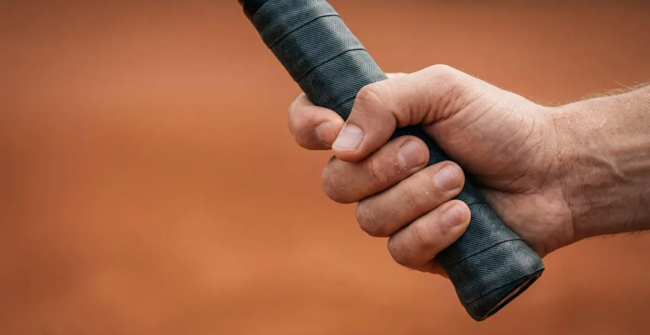 Détail macro de la préparation technique d'un revers à une main, montrant la fluidité et l'amplitude du mouvement